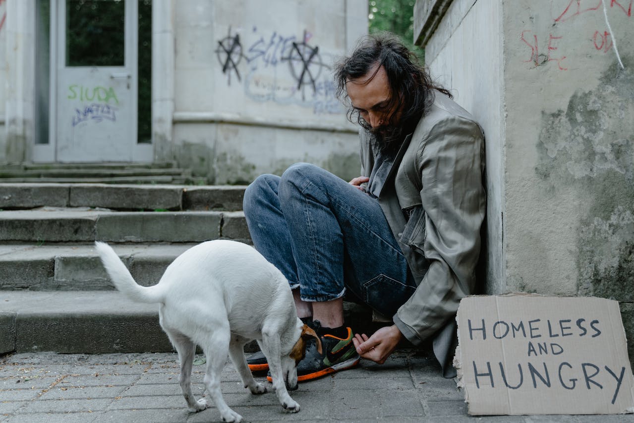 Homeless veteran feeding dog
